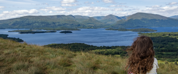 woman sitting overlooking a loch in Scotland