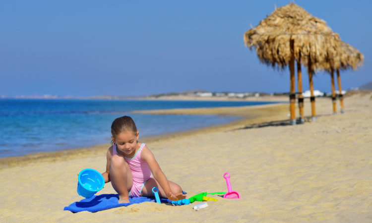 toddler girl enjoying her summer vacation at beach