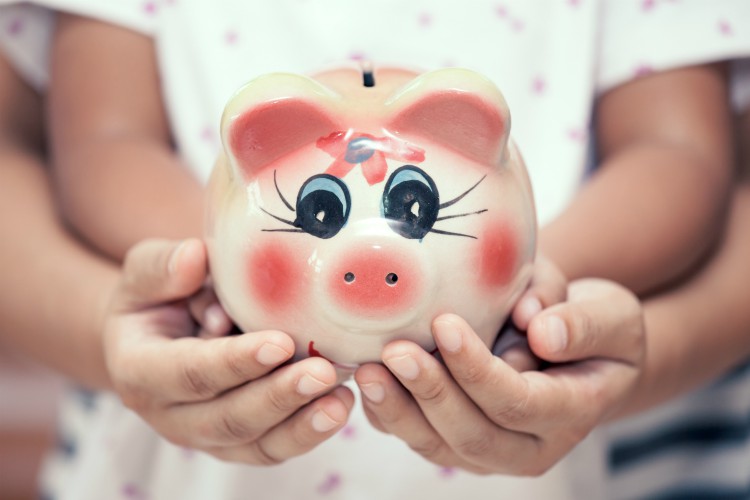 Piggy bank in child kid and mother hands in vintage color tone. family, saving, investments concept